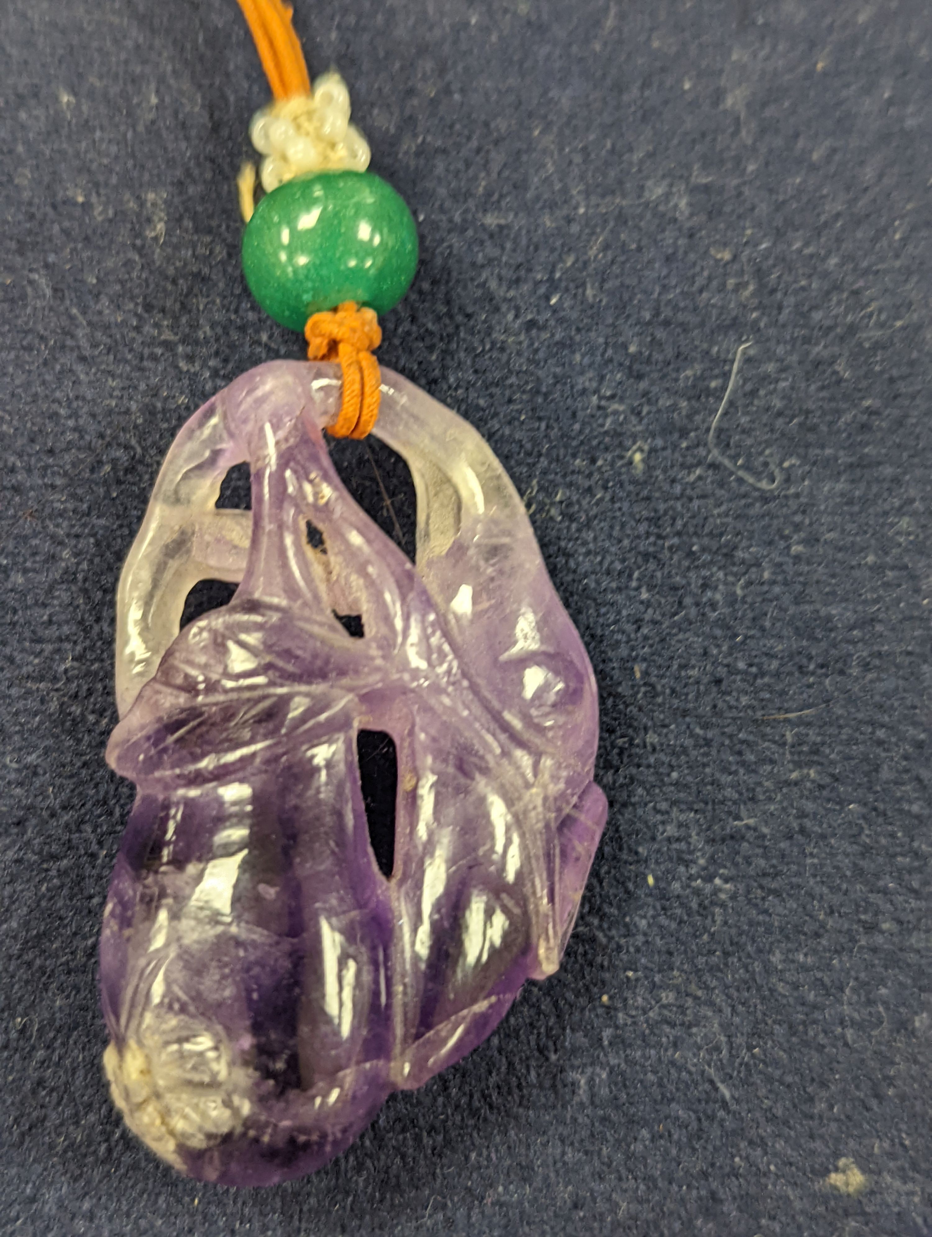 A 19th century Chinese carved amethyst pendant, 5cm on an ornate cord